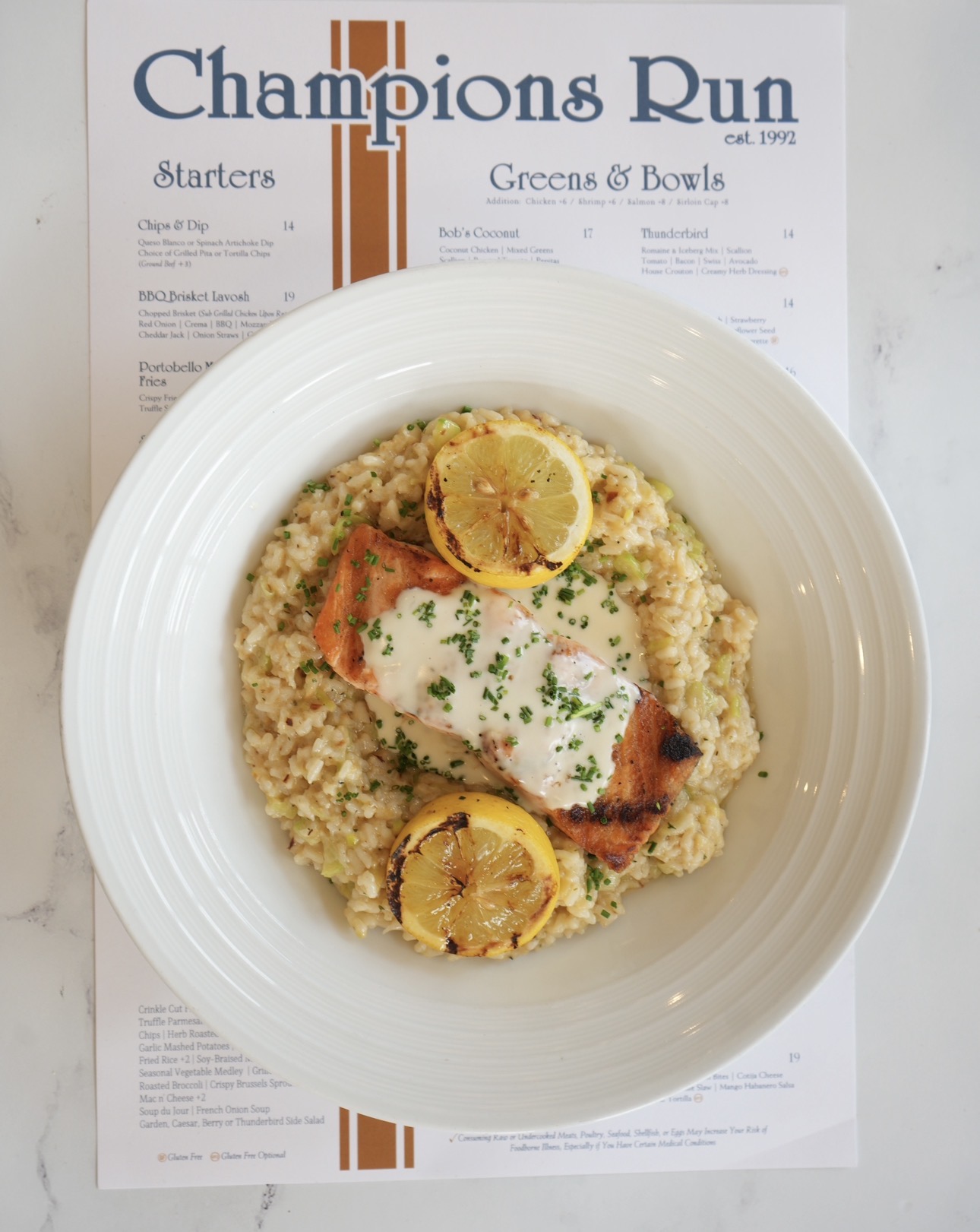 Champions Run salmon served over risotto with grilled lemon